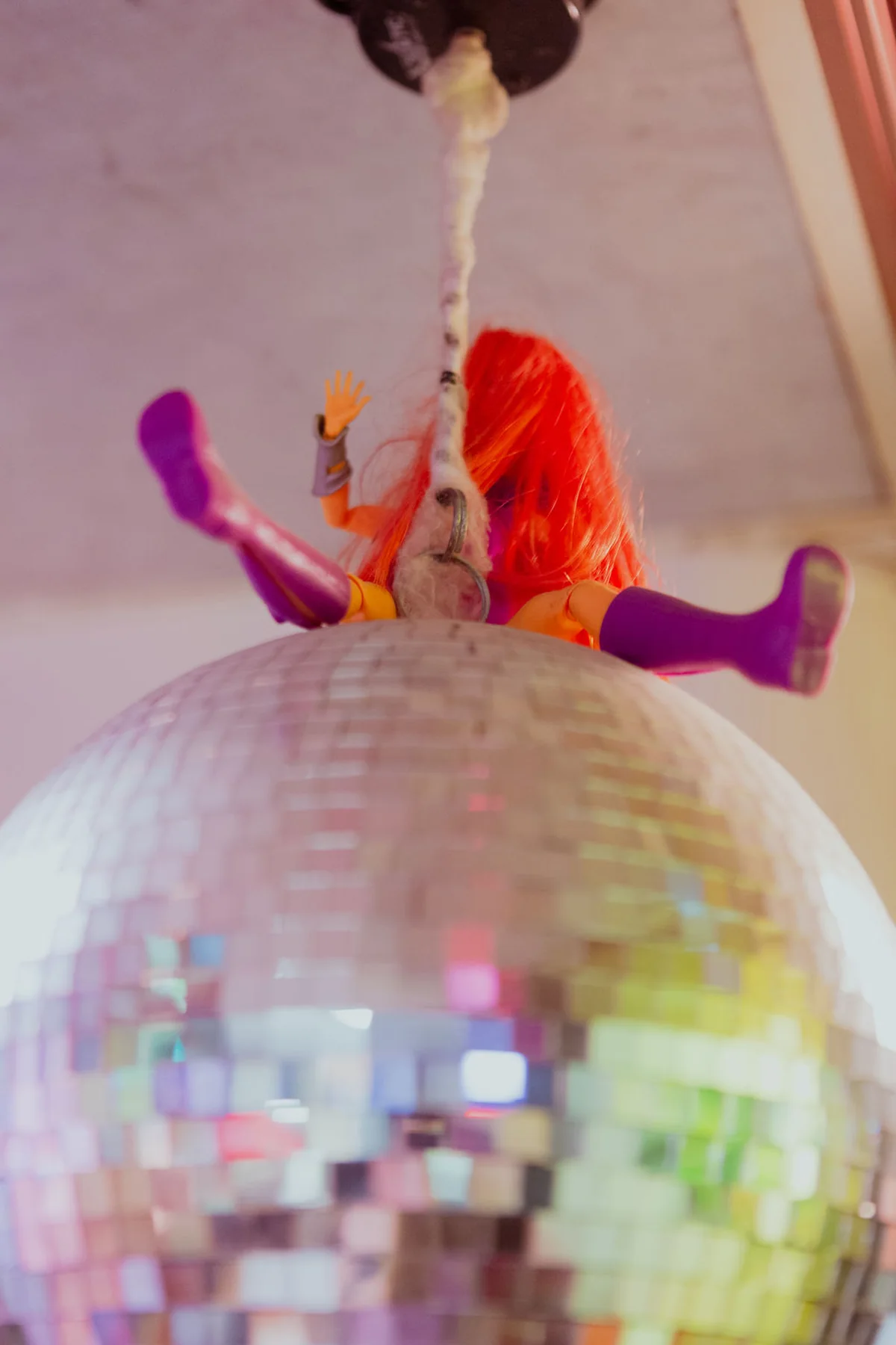 Orange-haired doll perched on a disco ball at Chinatown Soup