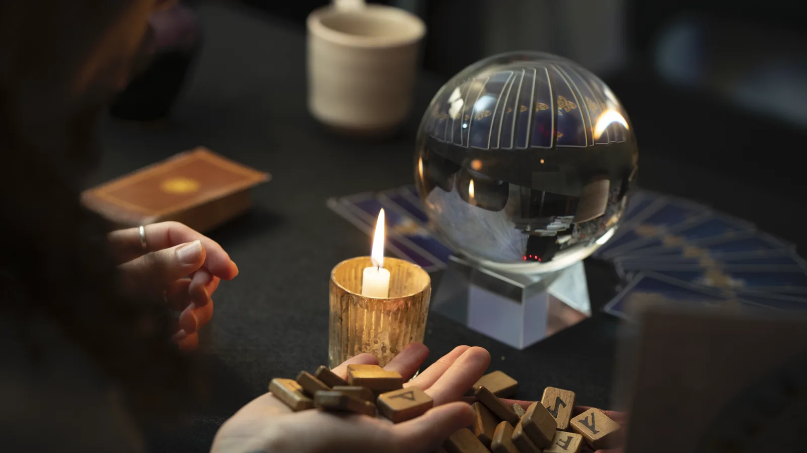 Spirit Soup: hands holding runes beside a candle and crystal ball