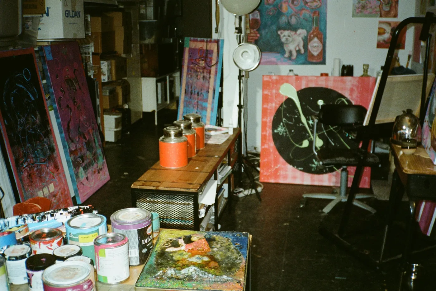 A working studio with canvases, paint cans, and an easel