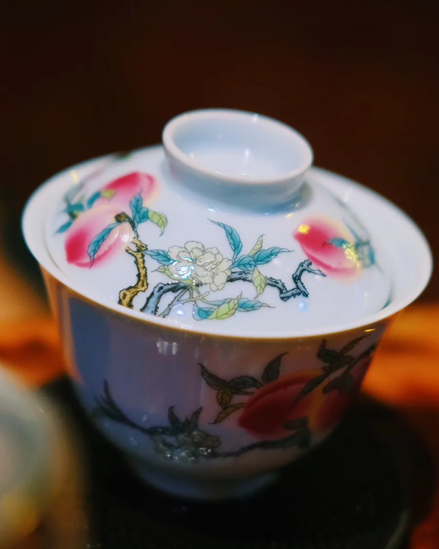 Peach-painted porcelain gaiwan on the tea table